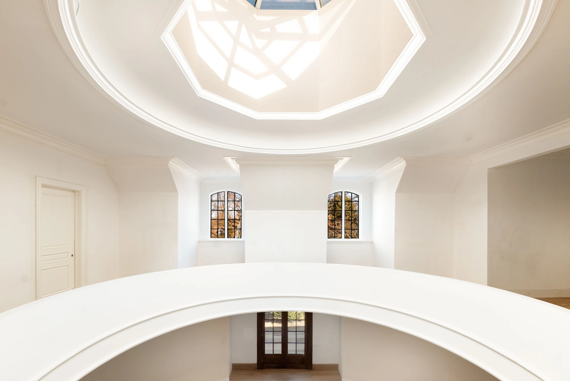 Circular atrium with curved balconies beneath an octagonal skylight at 5040 Independence Avenue