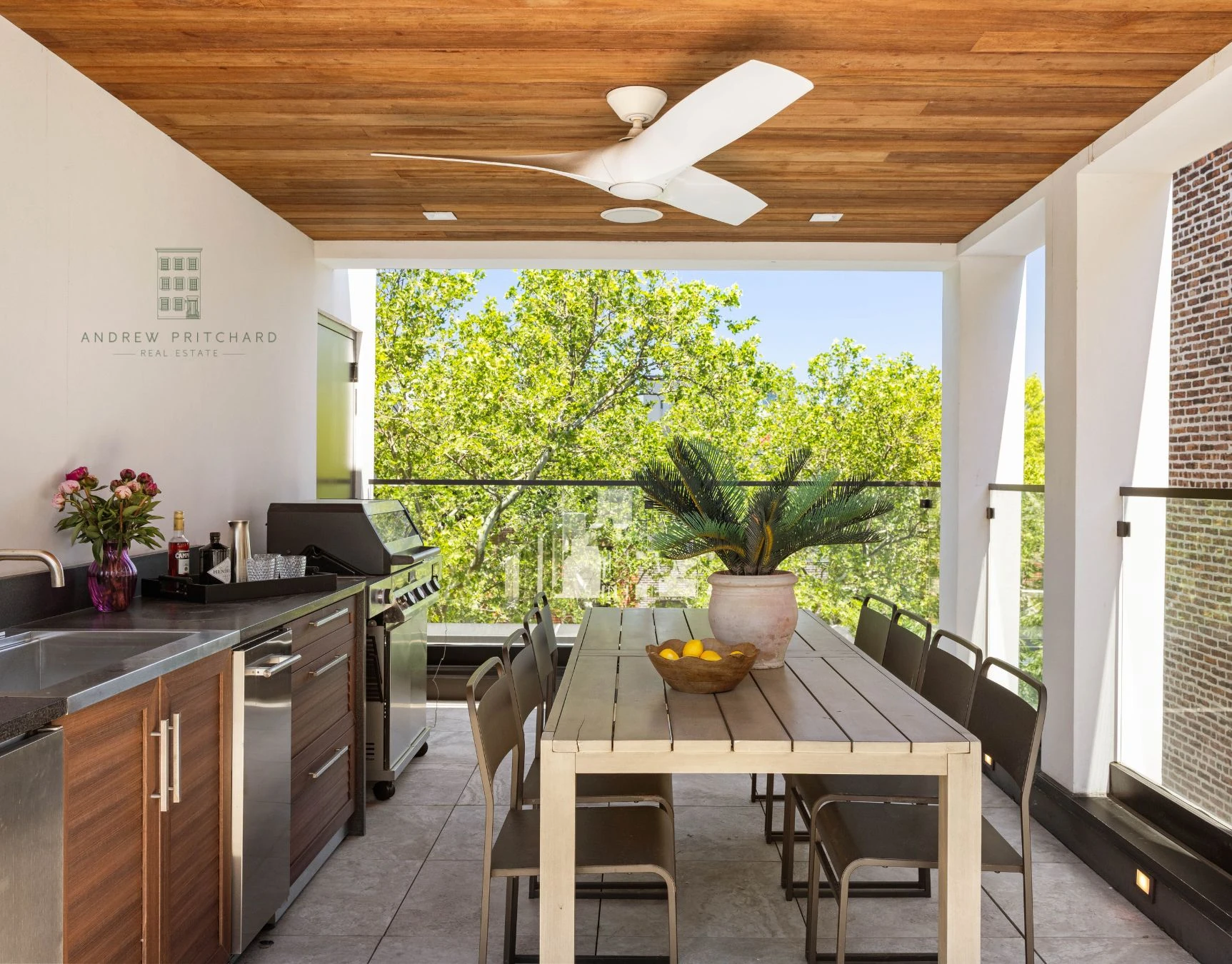 Covered rooftop loggia with outdoor kitchen and dining table at 232 Eighth Street