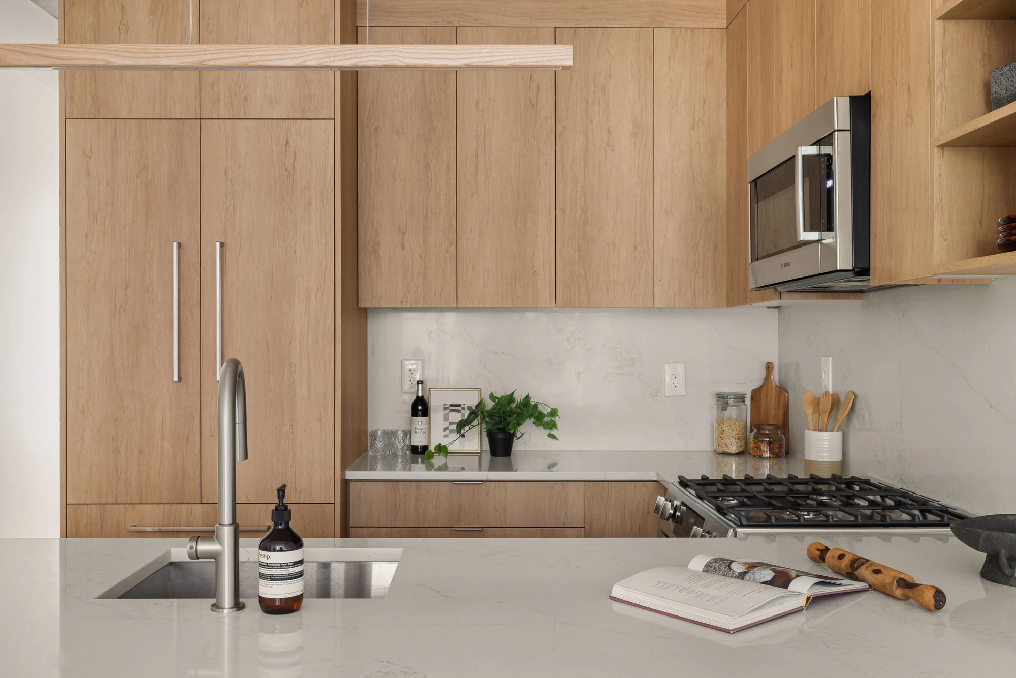 Light-wood cabinetry and quartz surfaces at 1230 Putnam Avenue