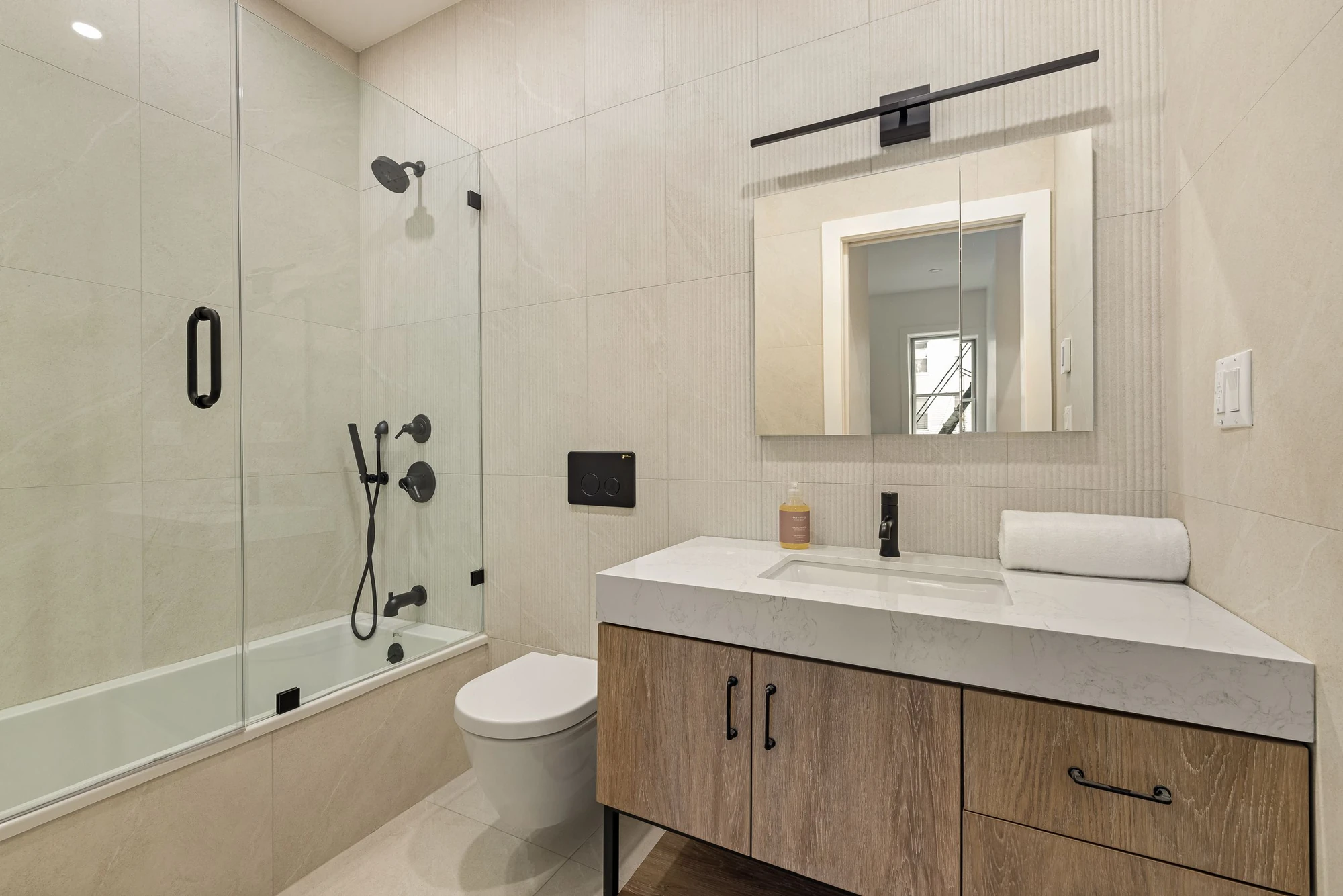 Bathroom with glass shower and wood vanity at 1230 Putnam Avenue