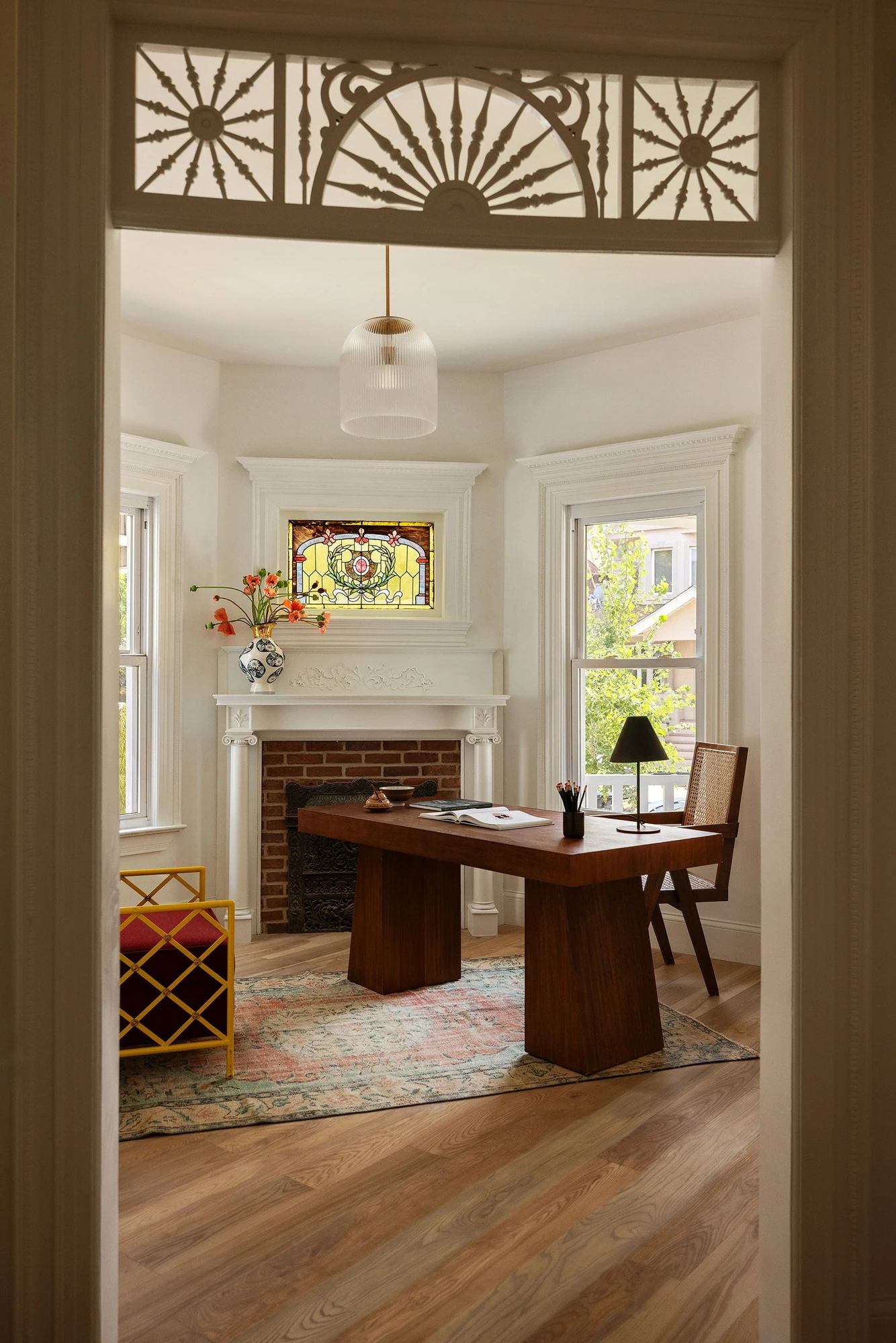 Octagonal library with a stained-glass window and exposed-brick fireplace at 534 East 24th Street