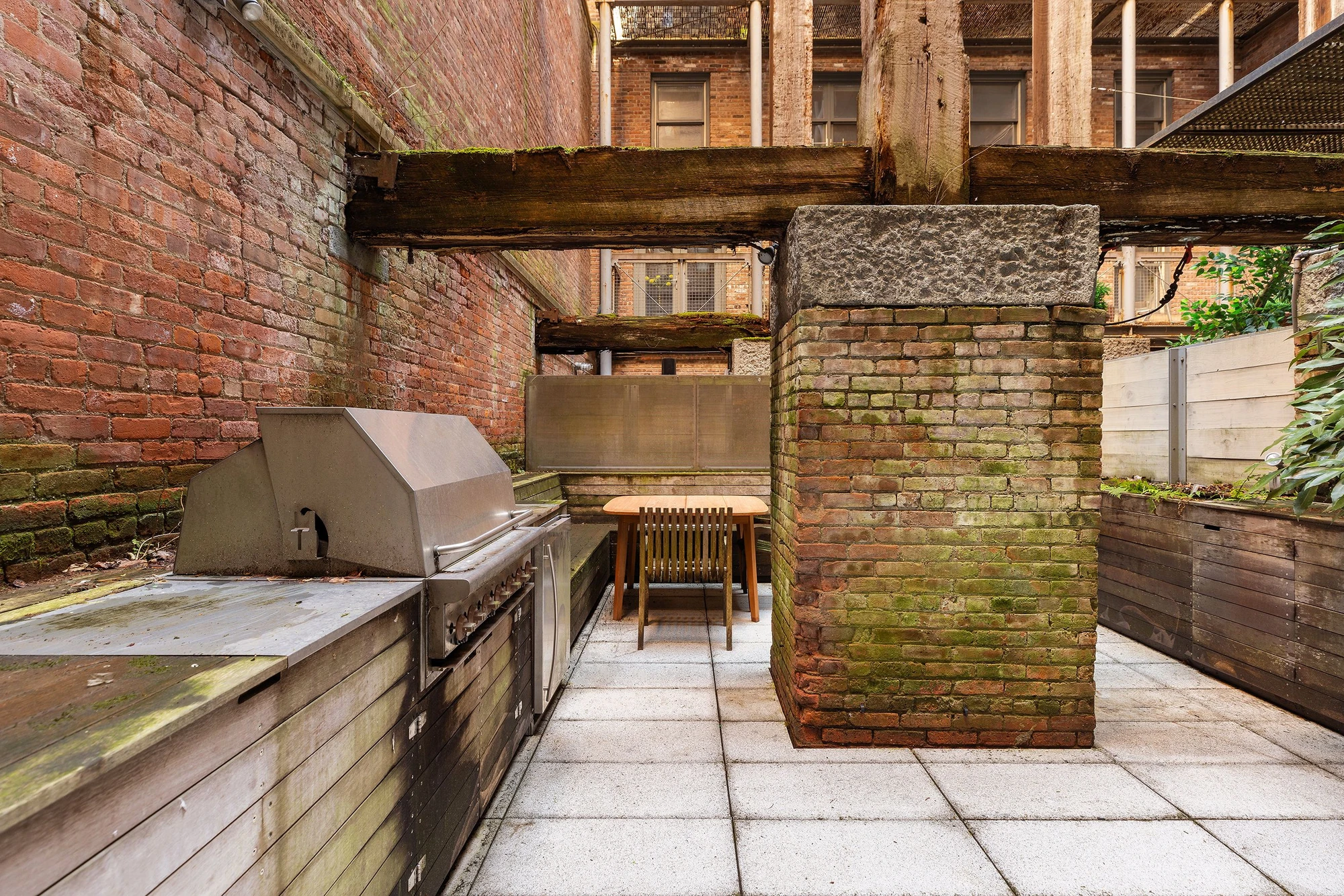 Patio with an outdoor kitchen, brick walls, and timber framing at 62 Beach Street
