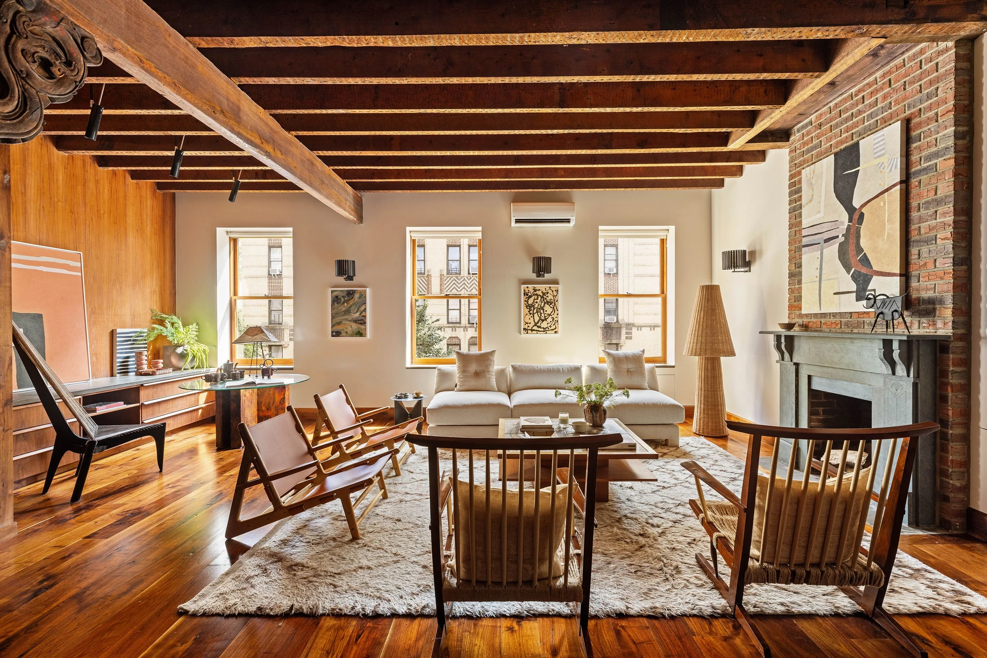 Wood-beamed living and dining room with a brick fireplace at 497 Saint John's Place