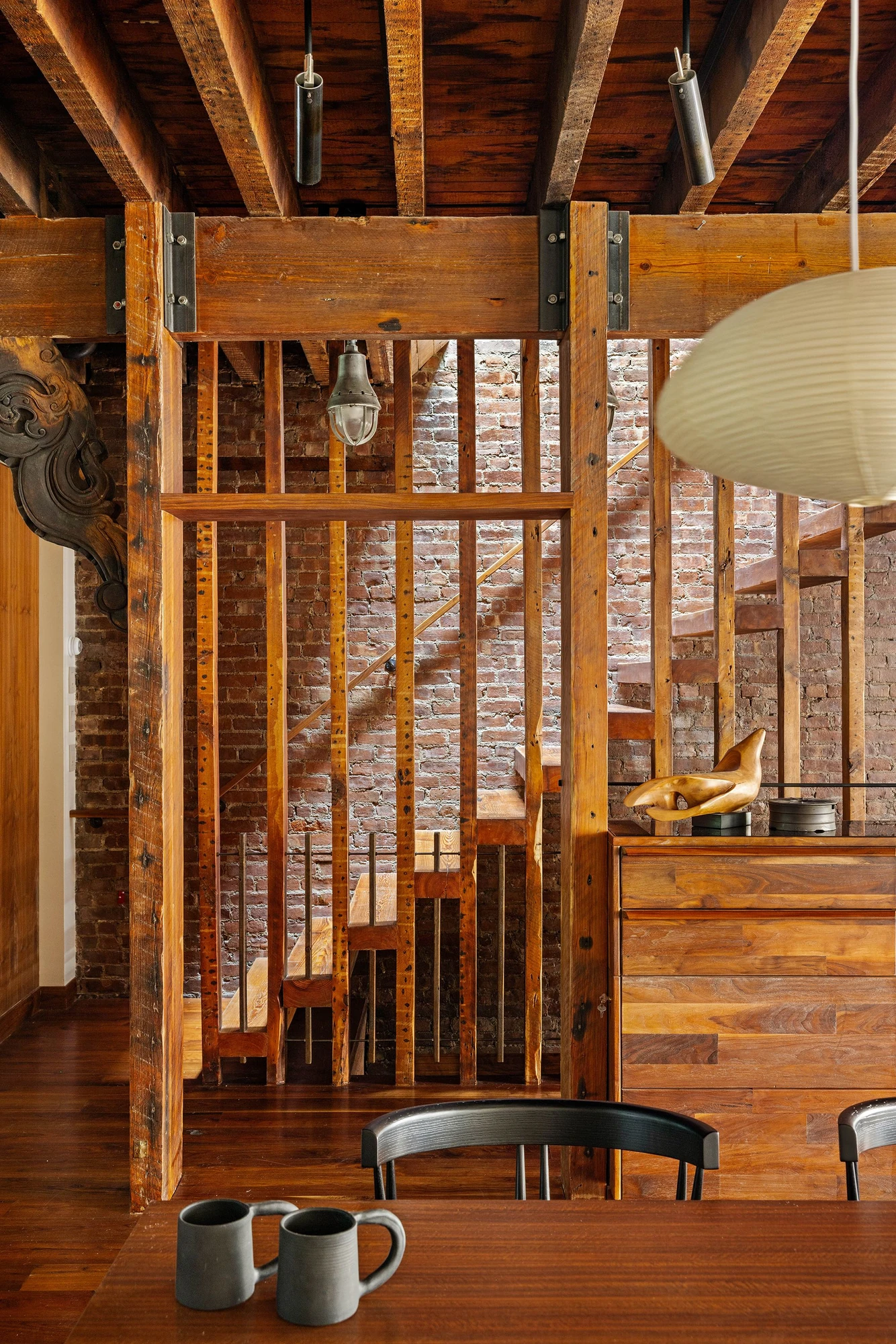 Exposed timber framing and brick beside an open staircase at 497 Saint John's Place