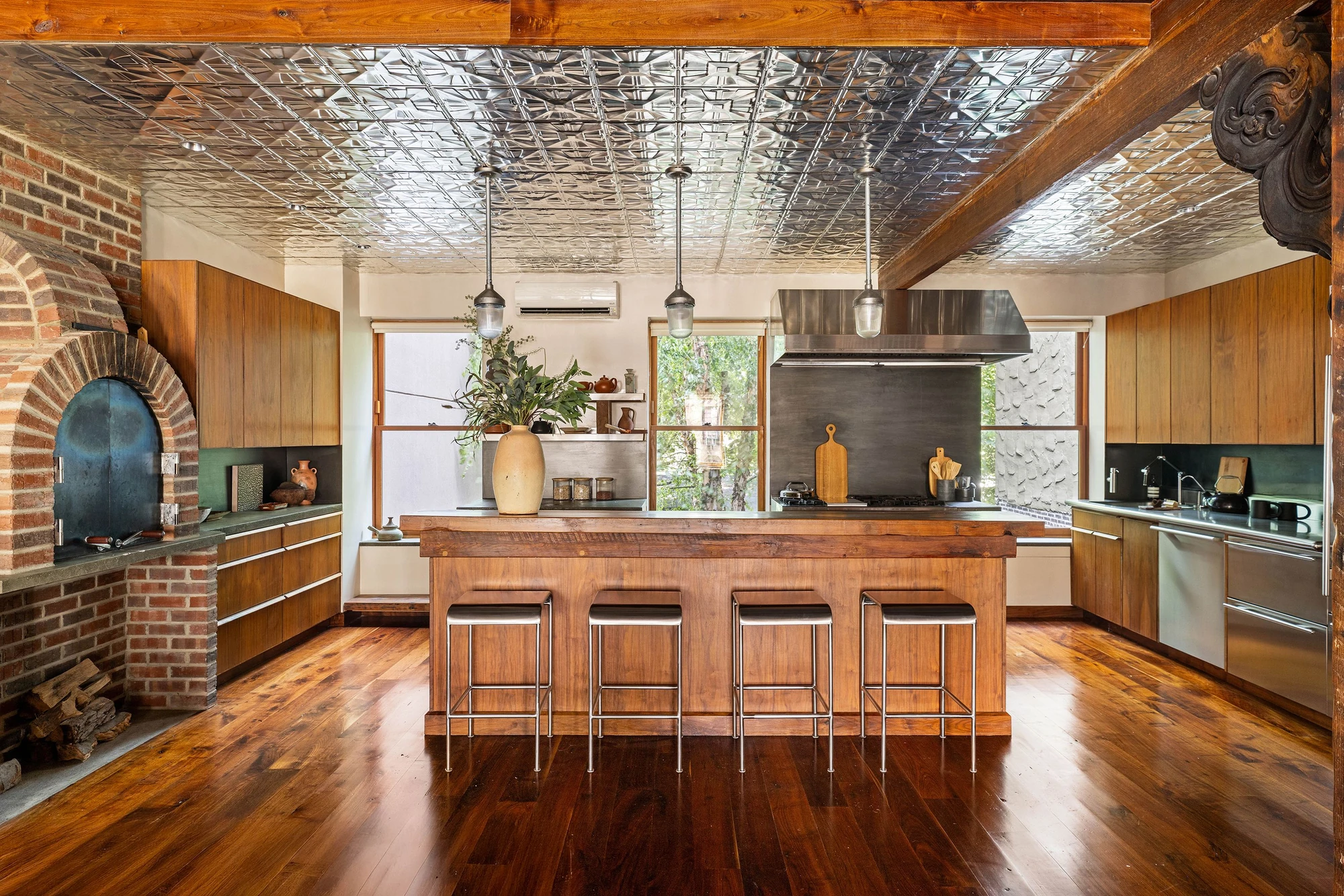 Kitchen with a patterned metal ceiling, wooden cabinets, and an arched brick oven at 497 Saint John's Place