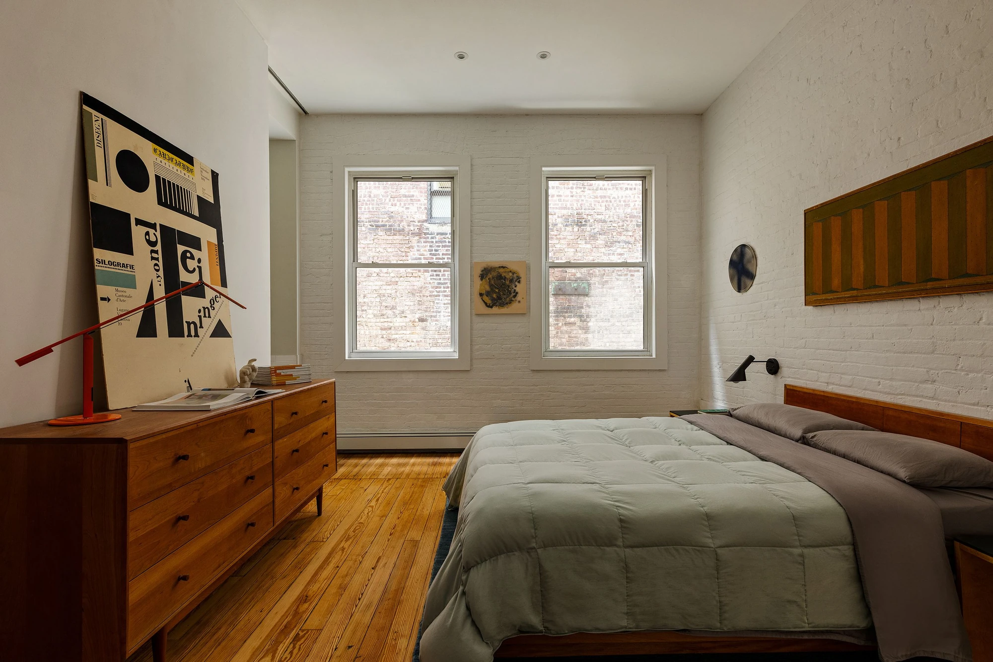 Bedroom with a white-painted brick wall and two windows at 62 Washington Avenue