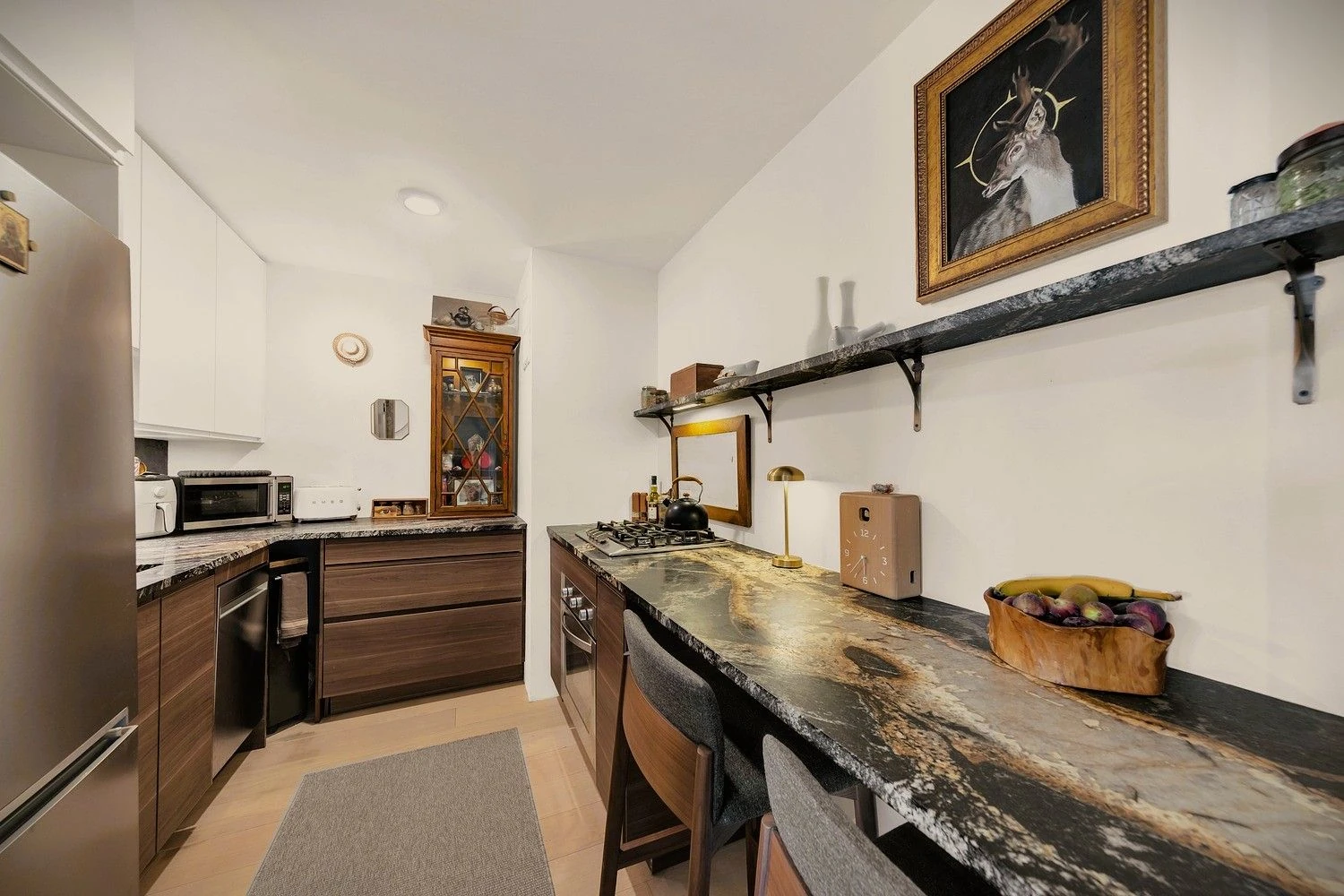 Wood kitchen cabinets with dark veined counters at 90 Gold Street #21F