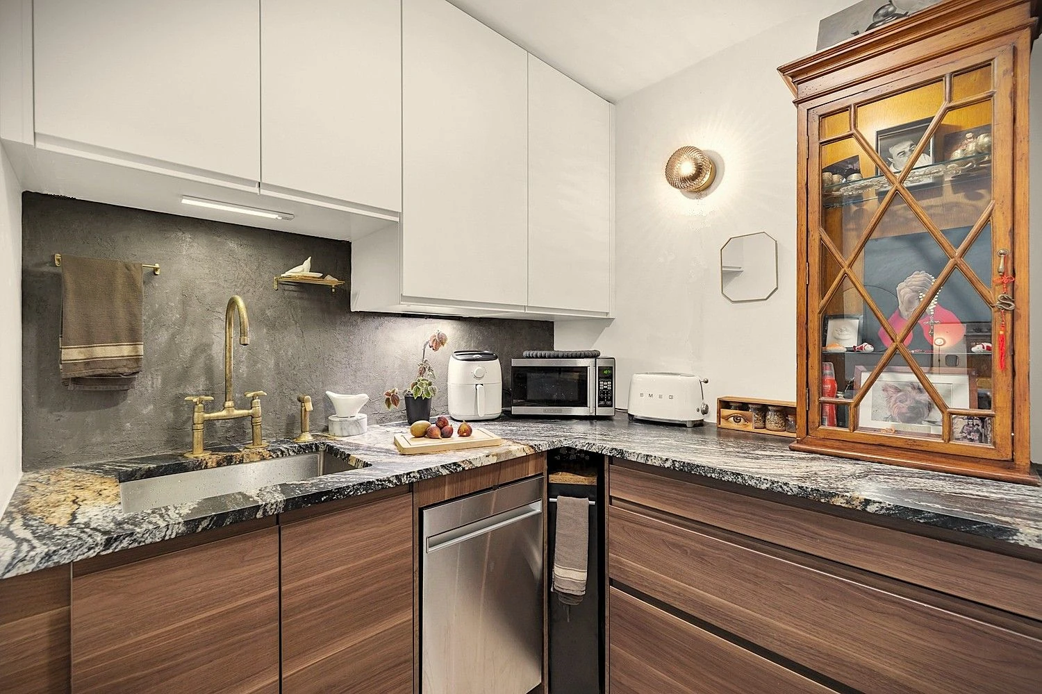 Gold-tone faucet, wood cabinets and dark veined counters at 90 Gold Street #21F