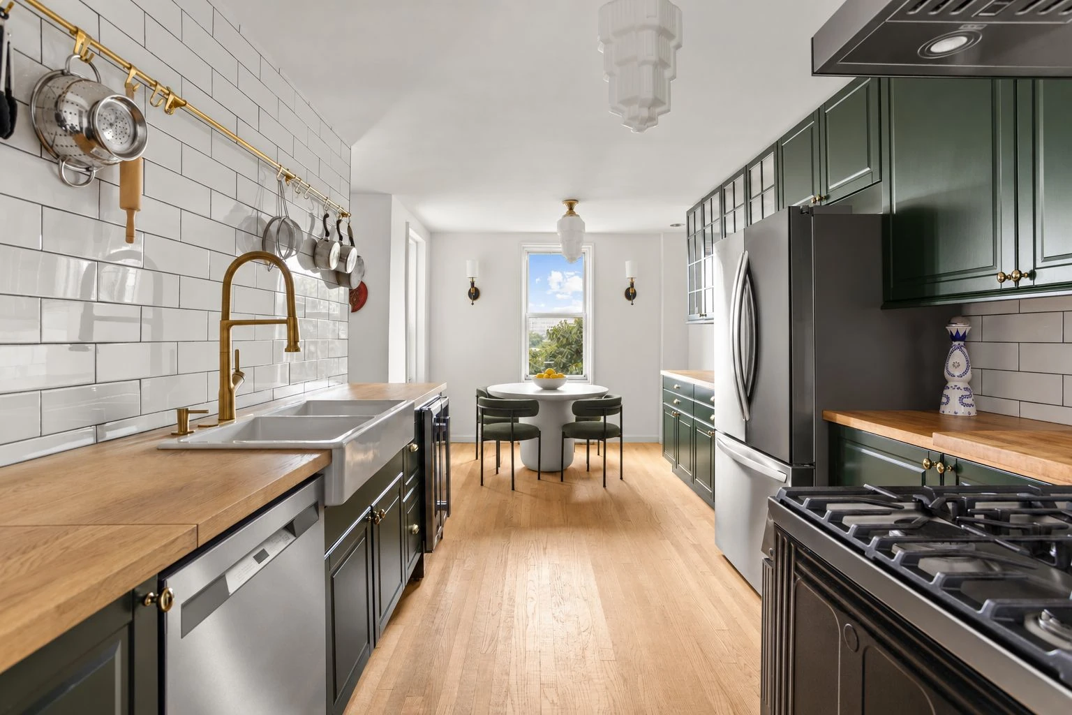 Green kitchen cabinetry, wood counters and a double-basin sink at 34-43 60th Street #4DE in Woodside