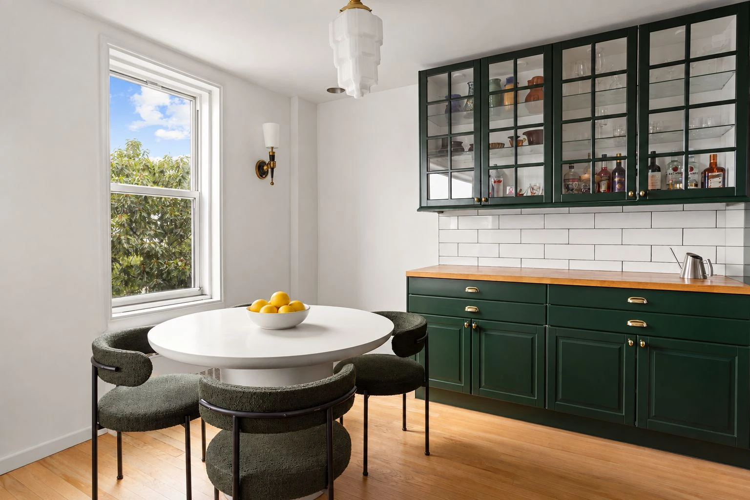 Small dining table at the end of the green kitchen at 34-43 60th Street #4DE