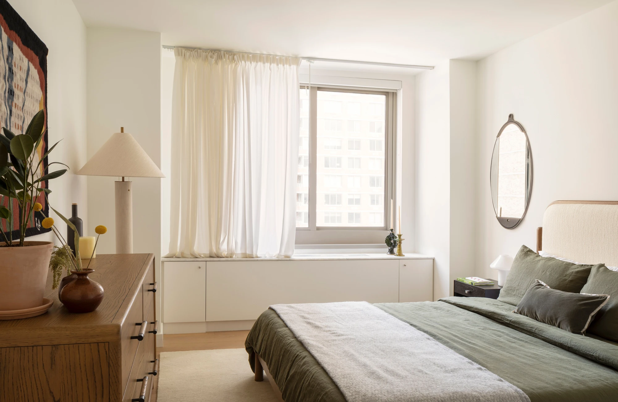 Bedroom with a window and wood storage furniture at The Perrie, 234 East 46th Street #701