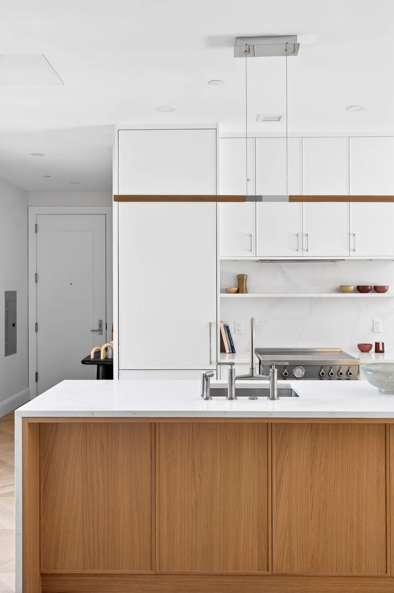 Wood-front kitchen island beneath simple pendant lights at 222 16th Street #4C