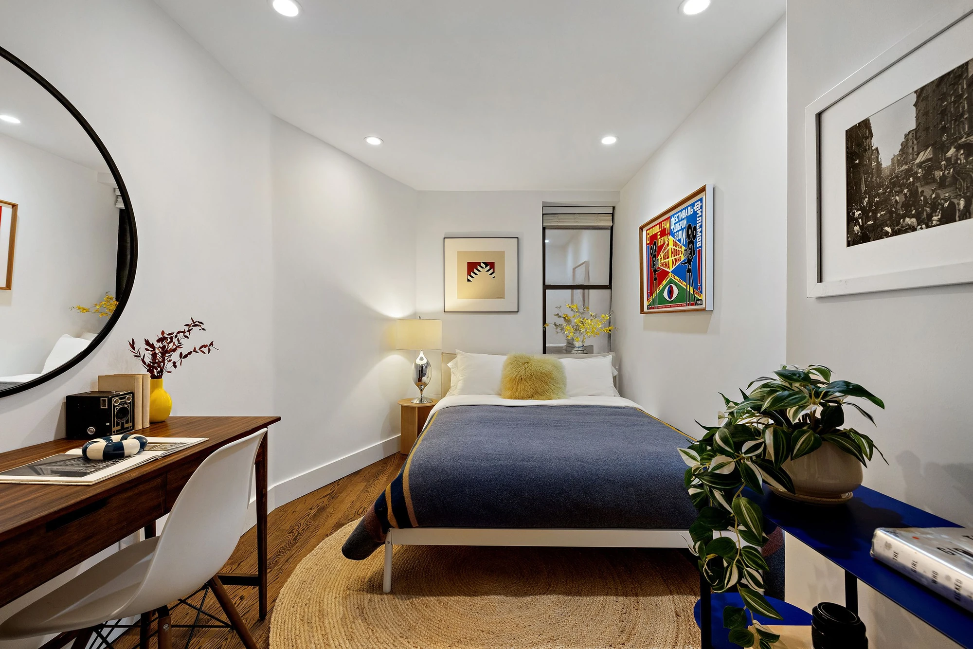 Lower-level bedroom with a bed, desk and white walls at 118 Suffolk Street #1B