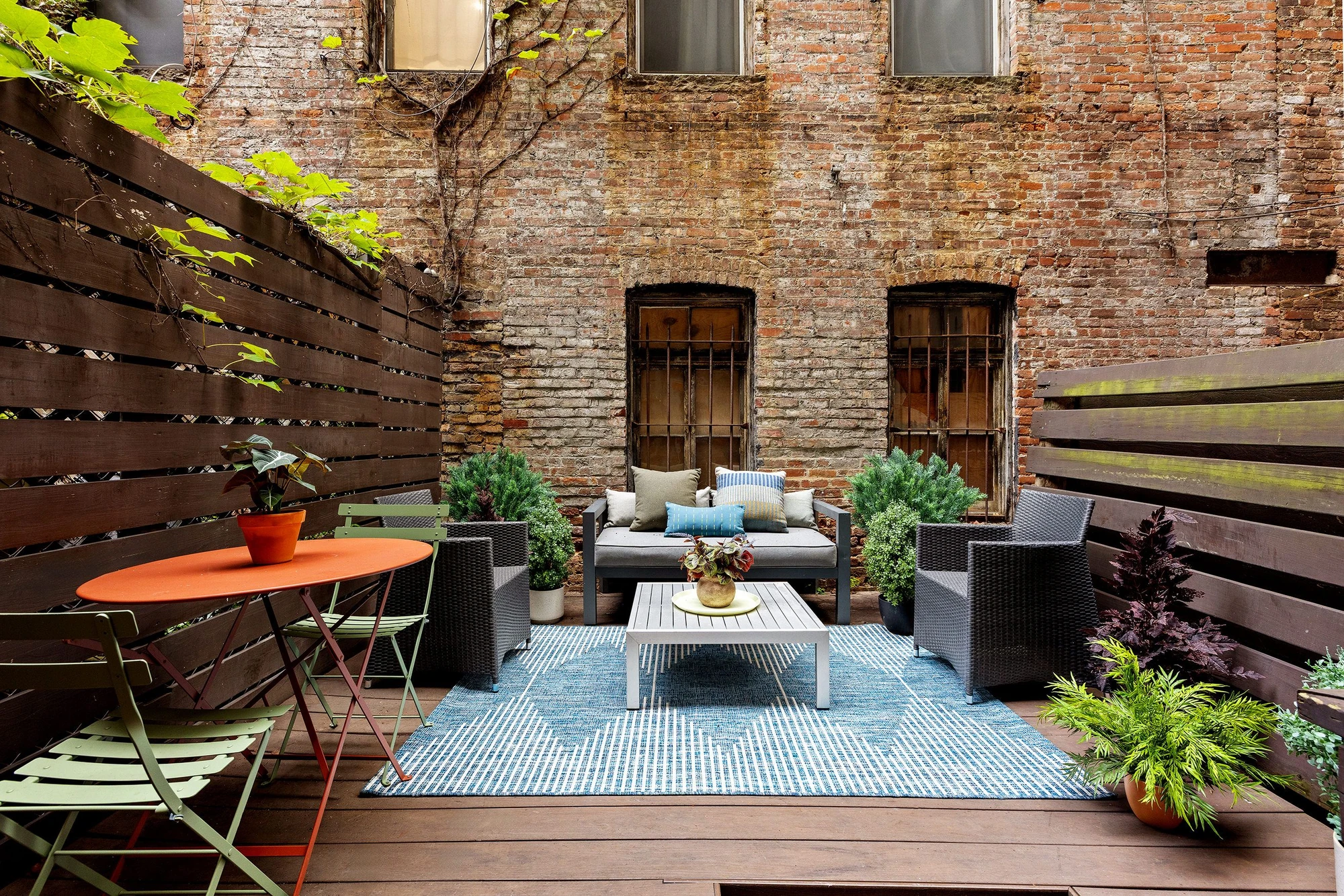 Private patio surrounded by brick walls, wood fencing and potted plants at 118 Suffolk Street #1B