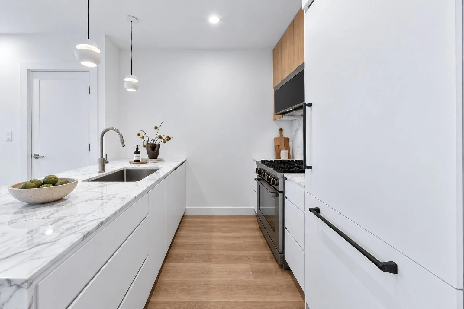 Developer illustration of a pale kitchen with a long peninsula at 1019 Hancock Street #1B