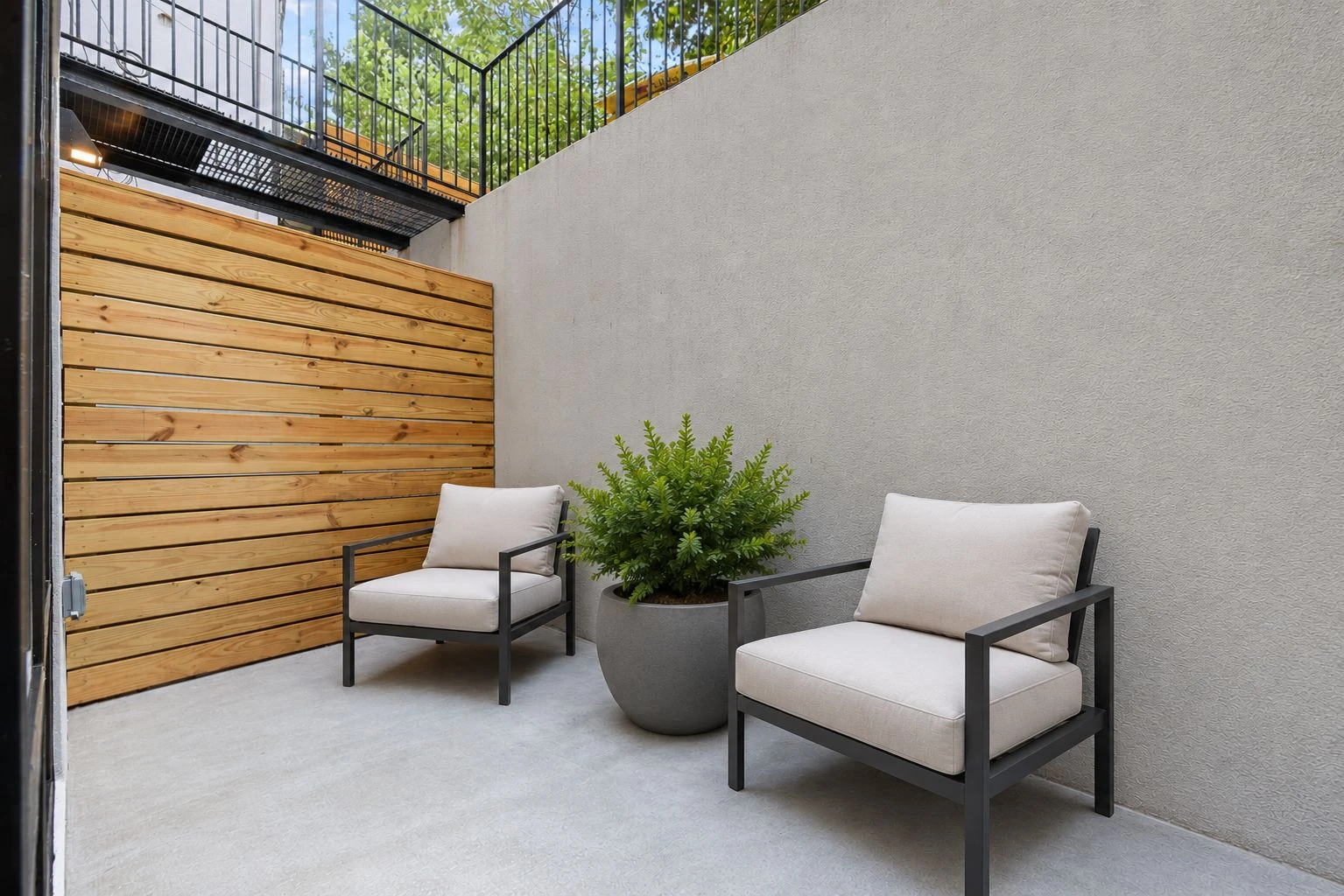Developer illustration of a lower-level areaway with two outdoor chairs at 1019 Hancock Street #1B