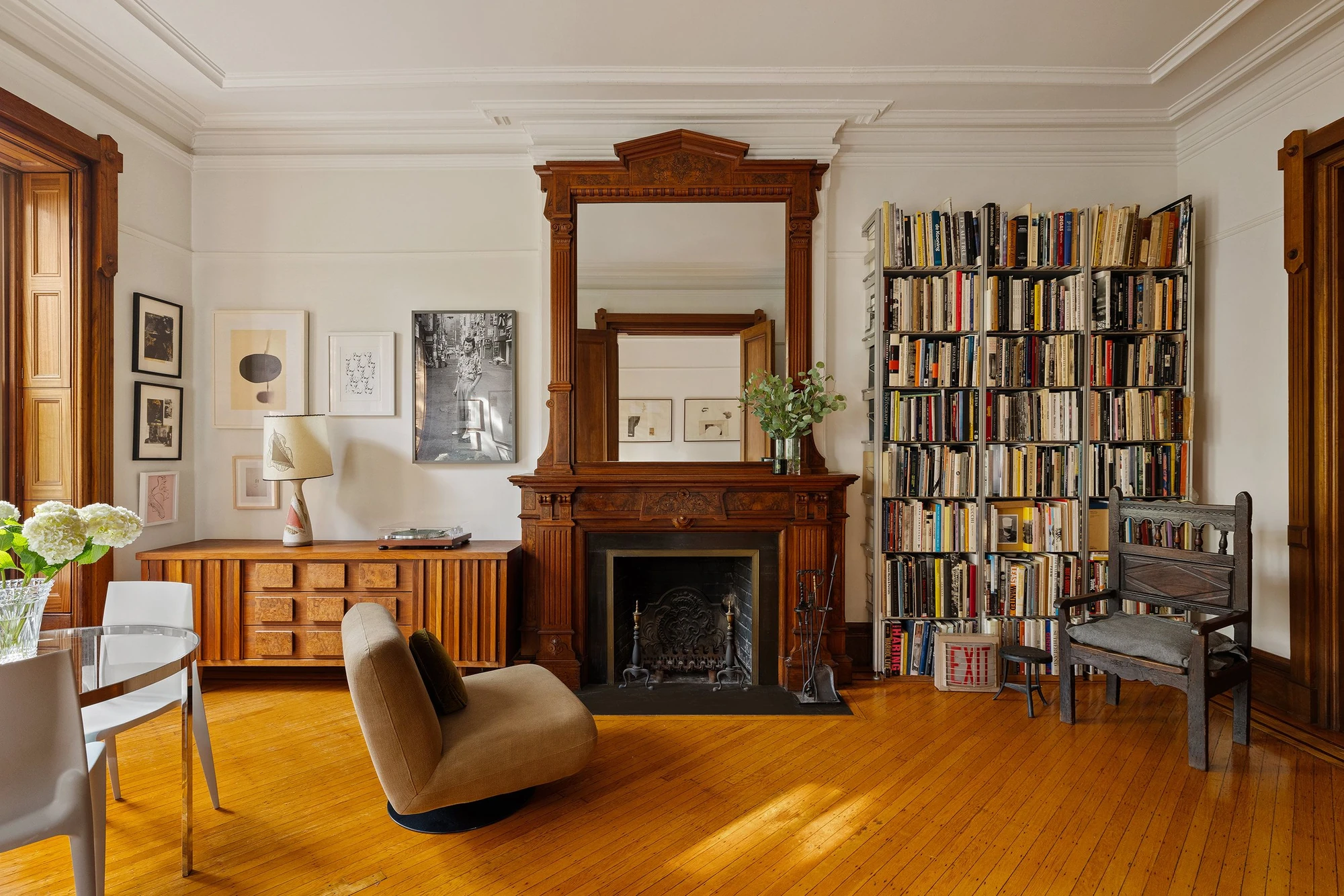 Living room with an ornate wood mantel, tall wood-framed windows and hardwood floors at 39 Remsen Street #4A