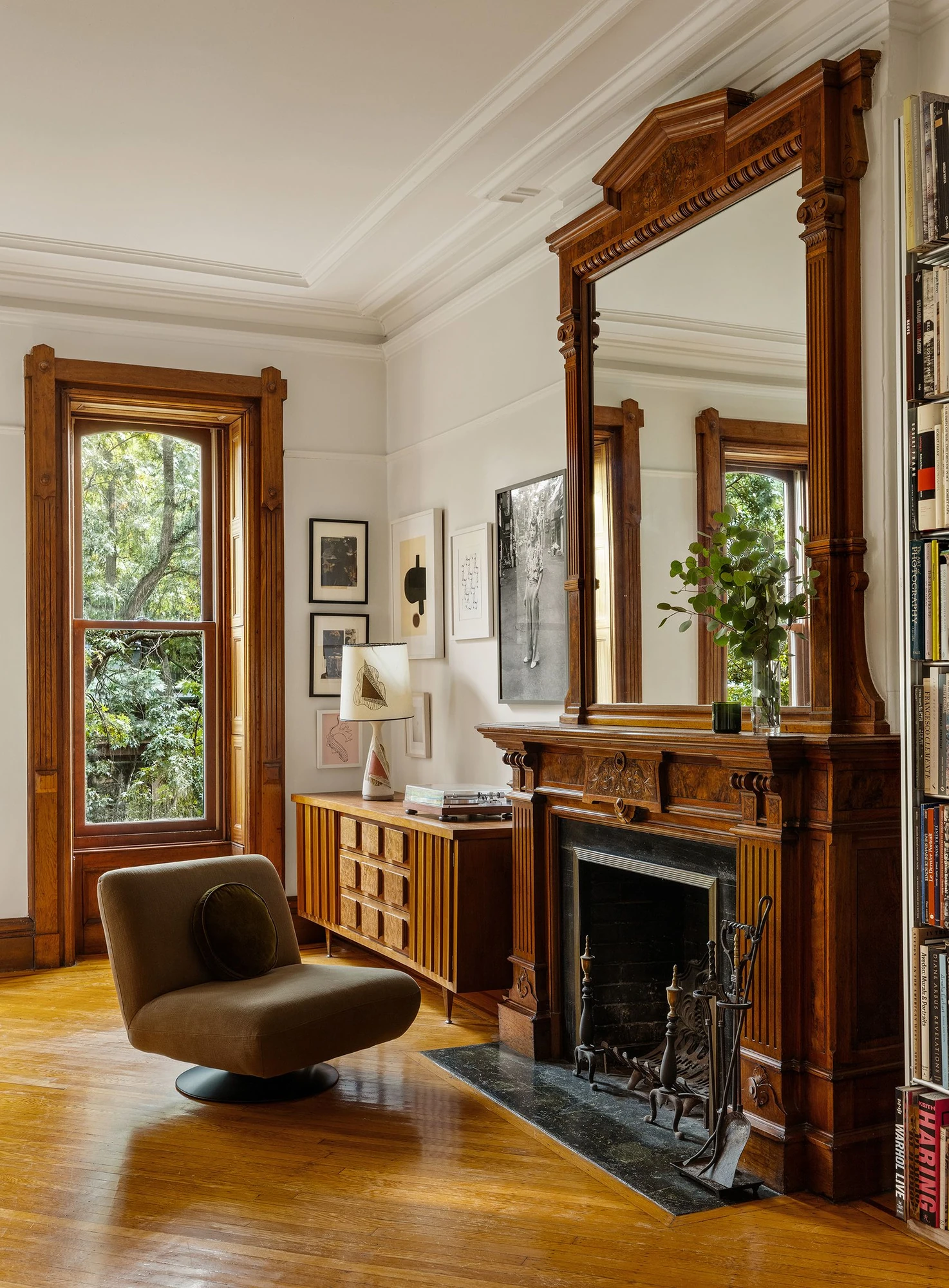 Carved wood mantel and fireplace surround beside a tall window at 39 Remsen Street #4A