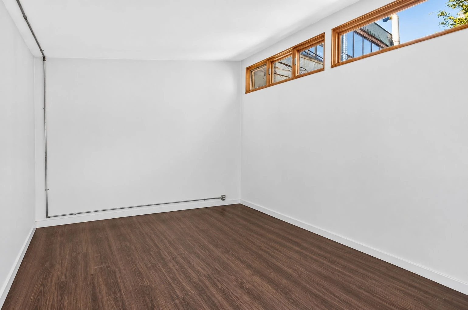 Vacant detached studio with wood flooring and high windows at 144 11th Street