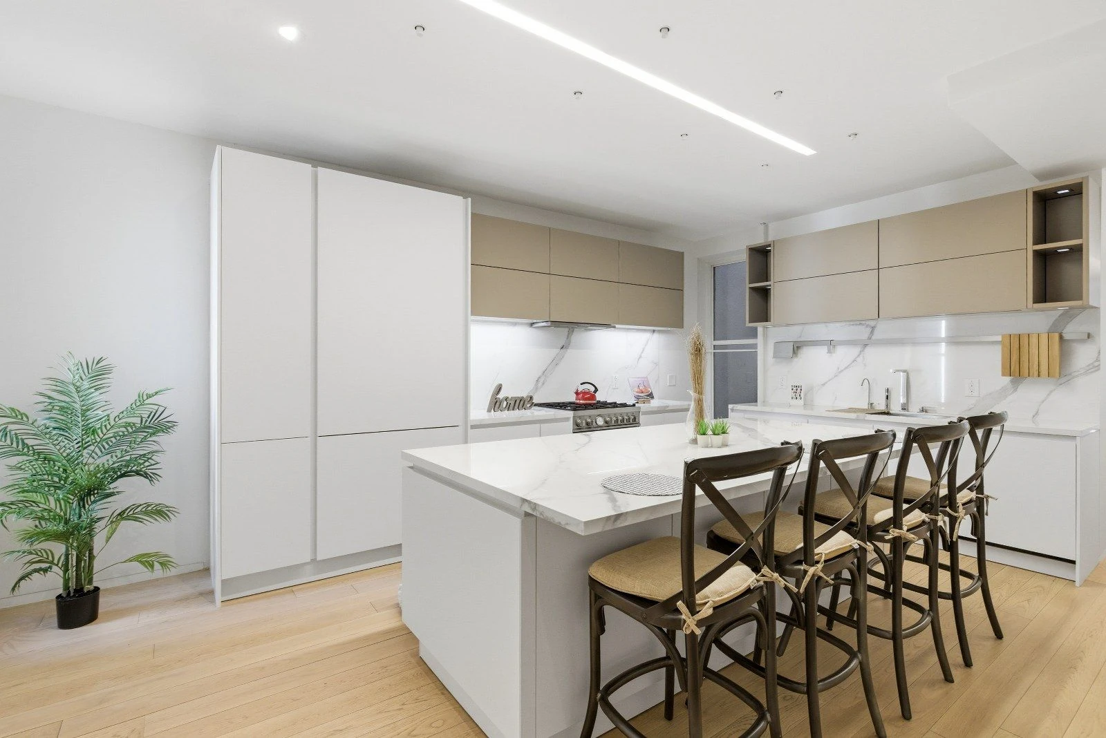 Marble kitchen island with seating and pale cabinetry at 205 East 124th Street #3BC