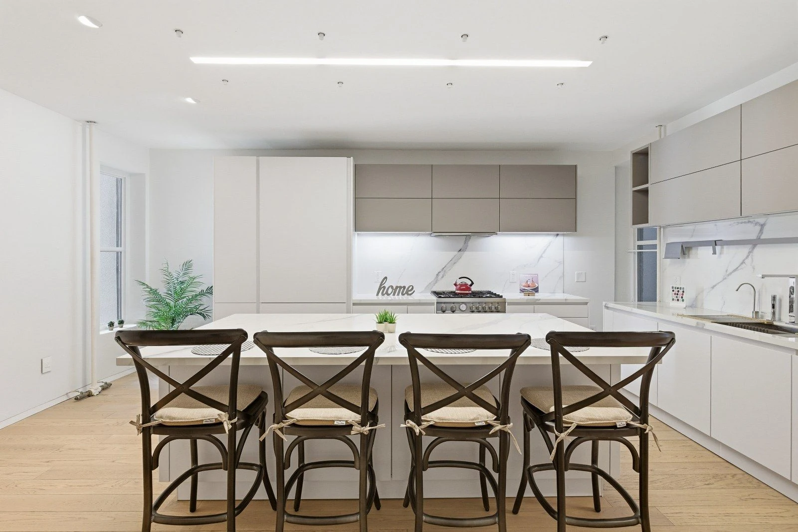 Wide marble kitchen counter and backsplash beneath a row of cabinets at 205 East 124th Street #3BC