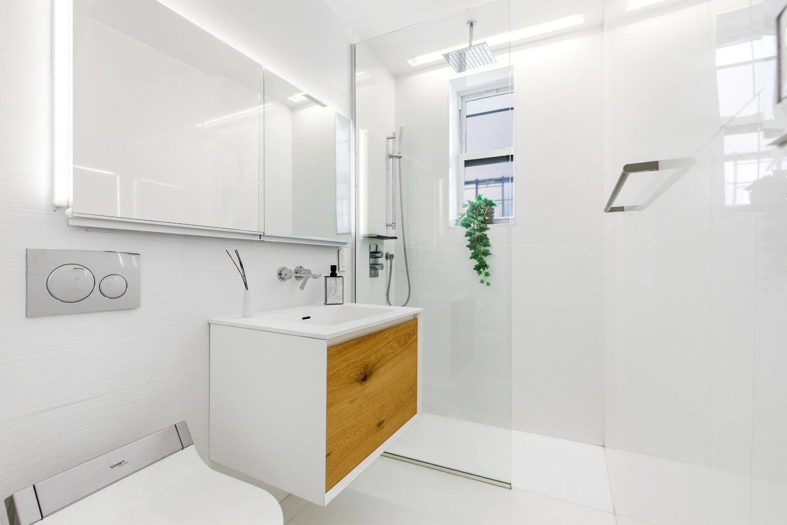 Bathroom with a floating wood vanity and a glass shower enclosure at 205 East 124th Street #3BC