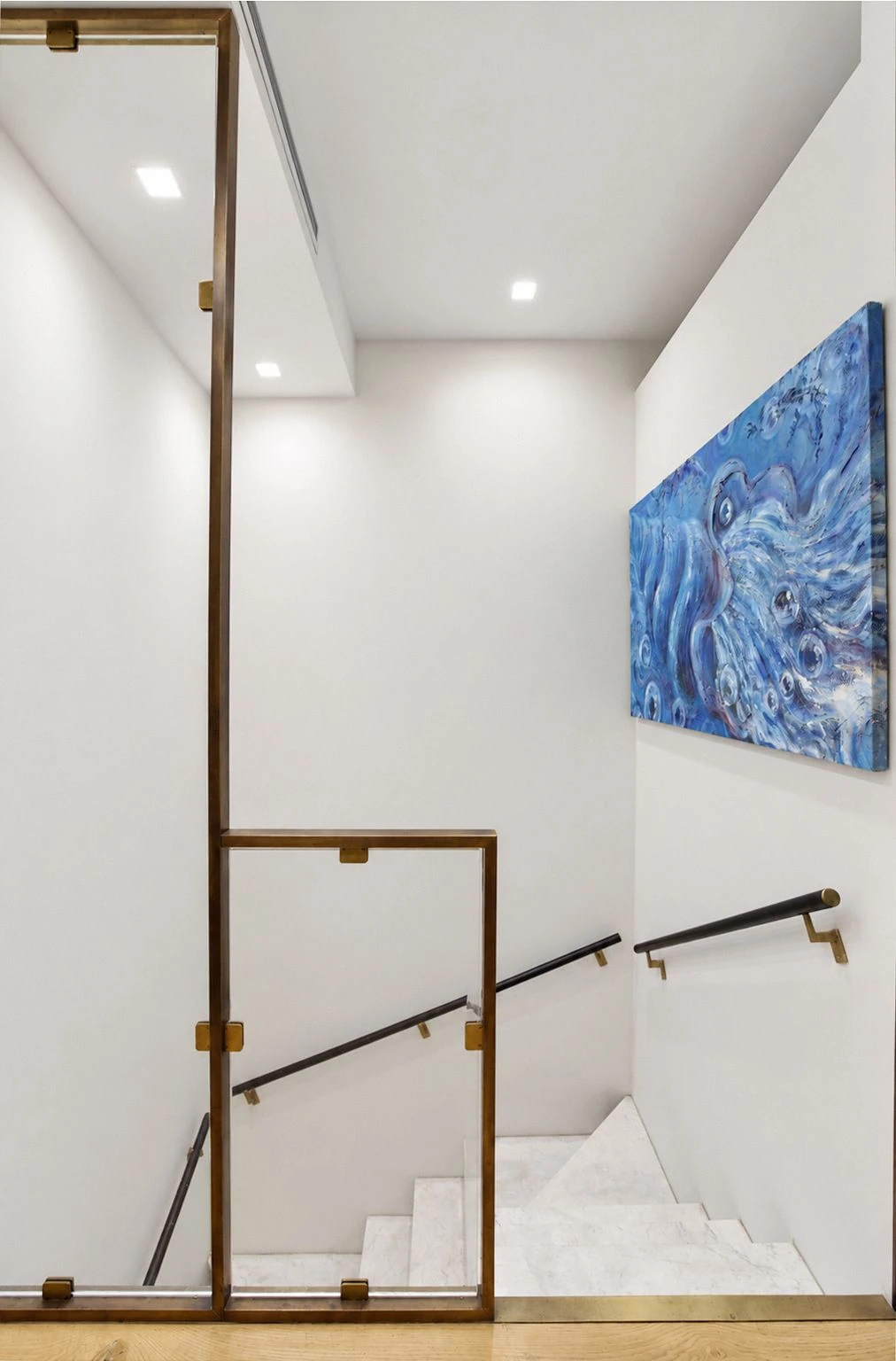 White marble staircase connecting the two levels at 257 West 117th Street #1E