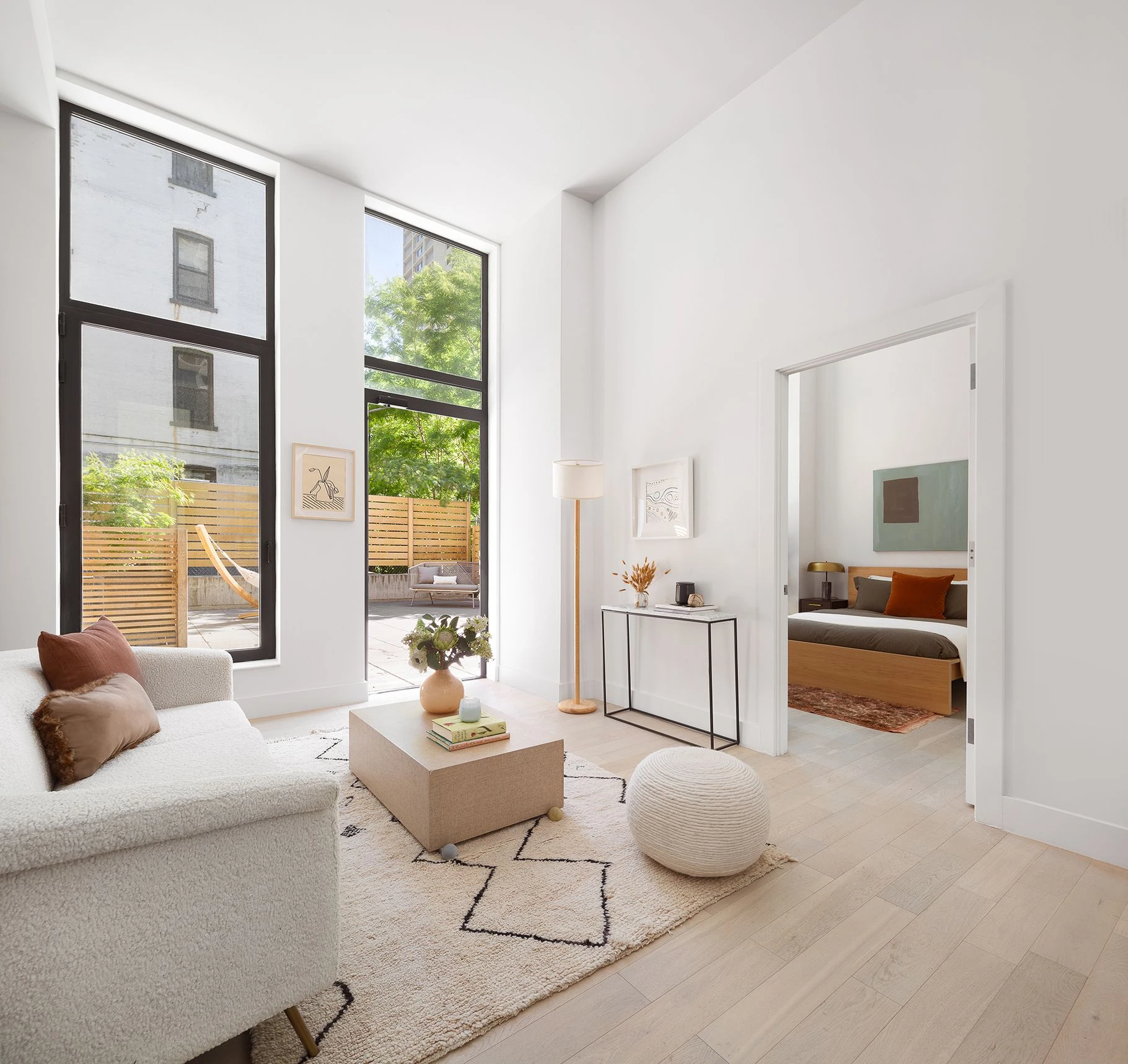 Living room with tall black-framed windows, pale wood floors and garden access at 111 Montgomery Street #B/1