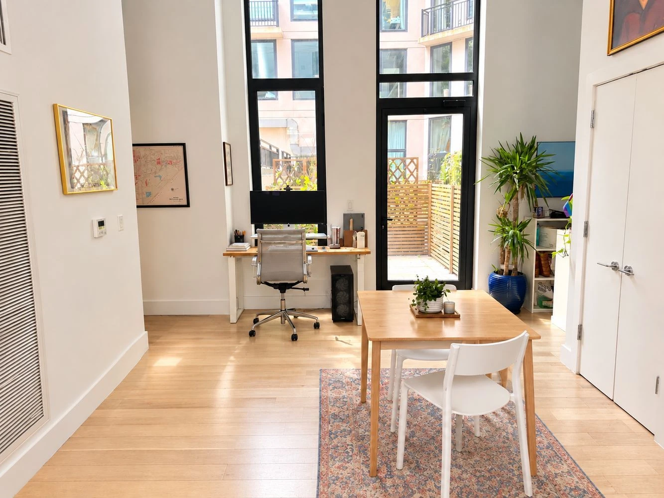 Dining and desk areas beside the tall living-room windows at 111 Montgomery Street #B/1