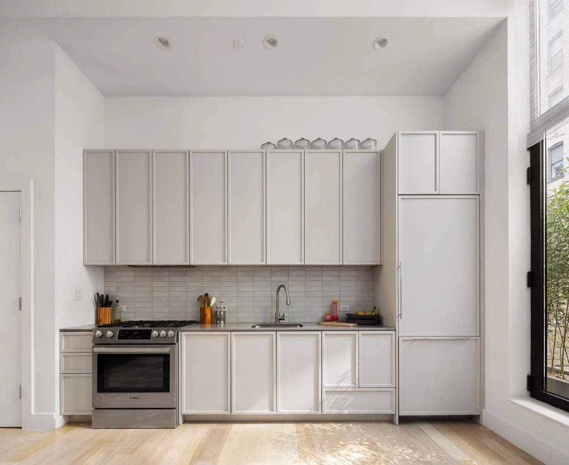 White kitchen cabinetry and counters along the open living space at 111 Montgomery Street #B/1