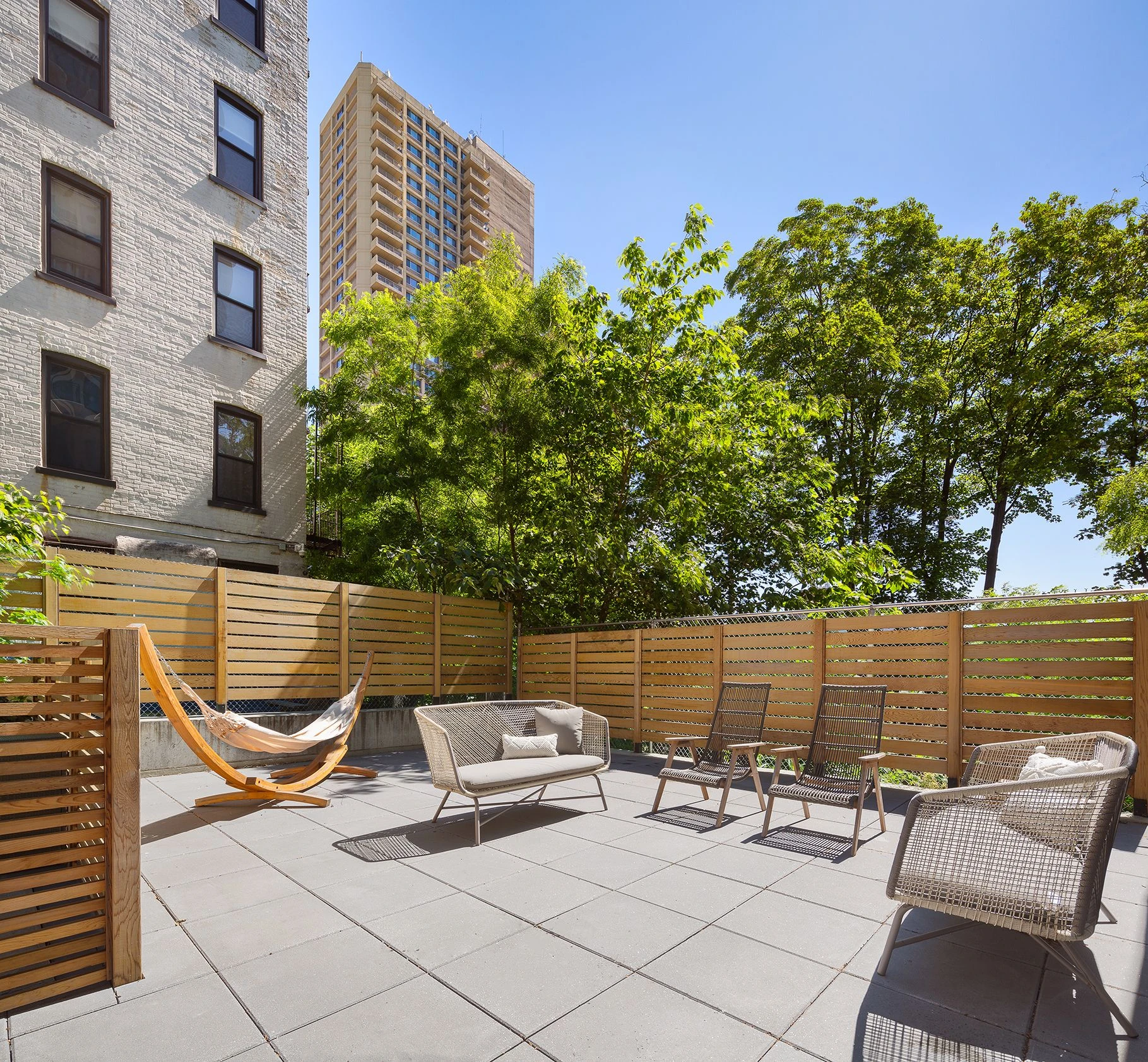 Private outdoor seating area with paving, wood fencing and planting at 111 Montgomery Street #B/1