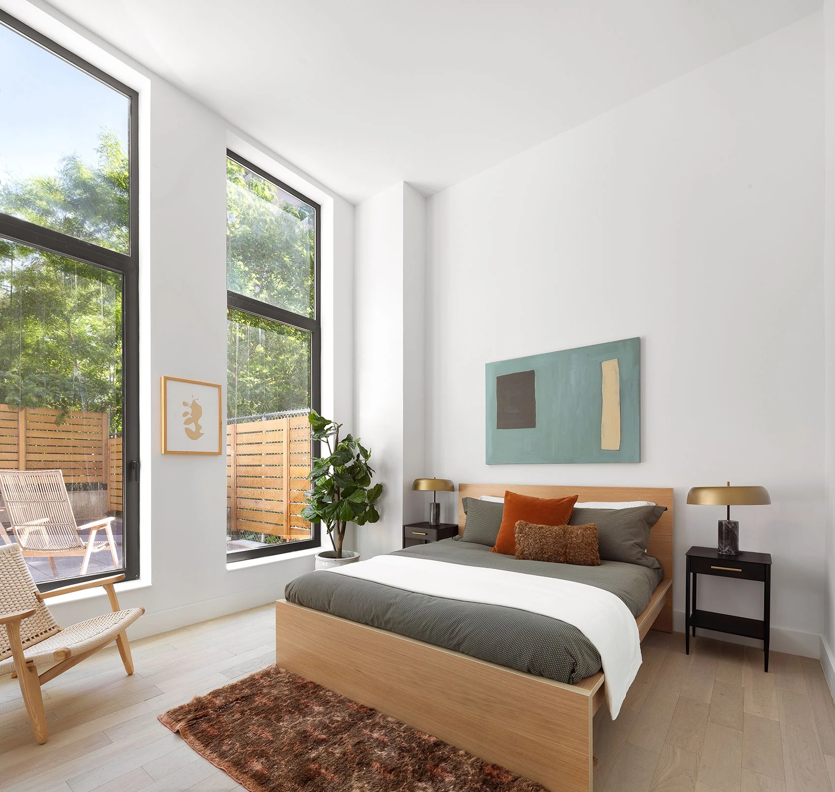 Bedroom with tall windows and a glazed door facing outdoor planting at 111 Montgomery Street #B/1