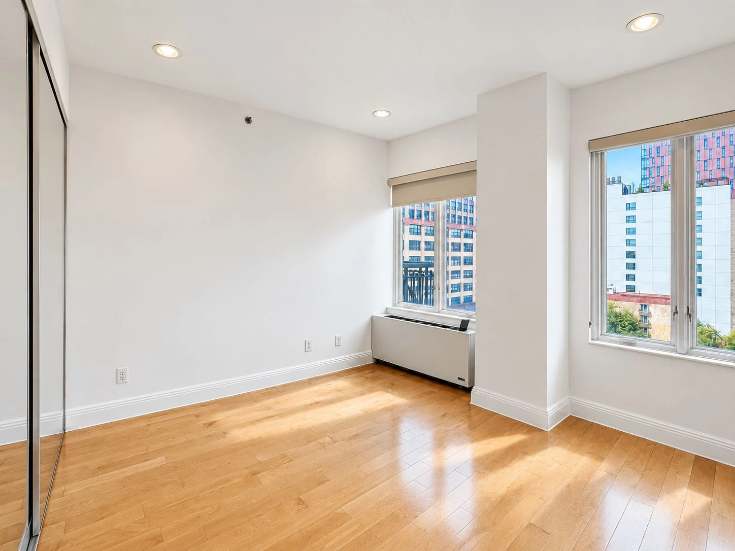 Vacant bedroom with two windows and wood flooring at 197 Bridge Street #8C